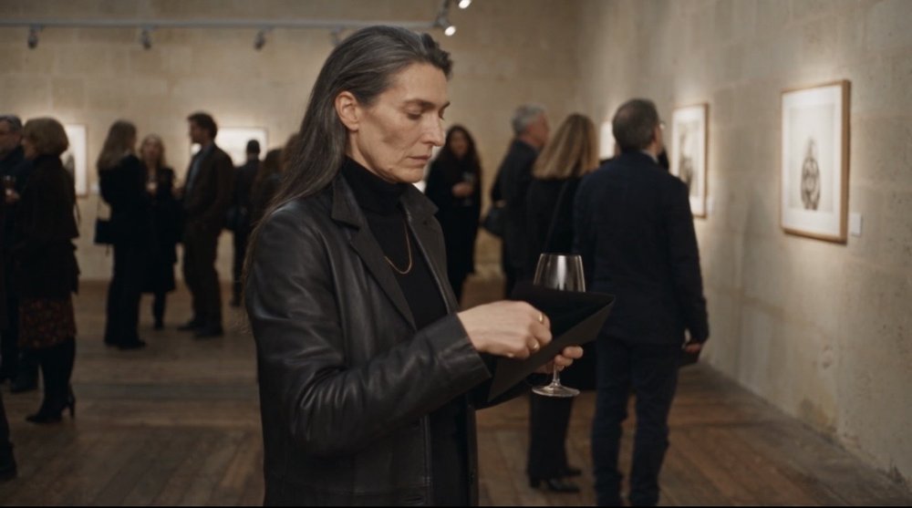 Fotogramma: una donna prende appunti a un vernissage